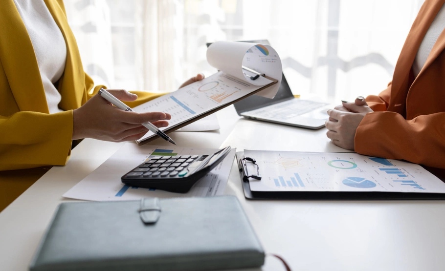 Accountants Wirral. An image of a one to one meeting with an accountant taking place with a business owner, looking over the financial forecasting sheet prepared by the accountant.